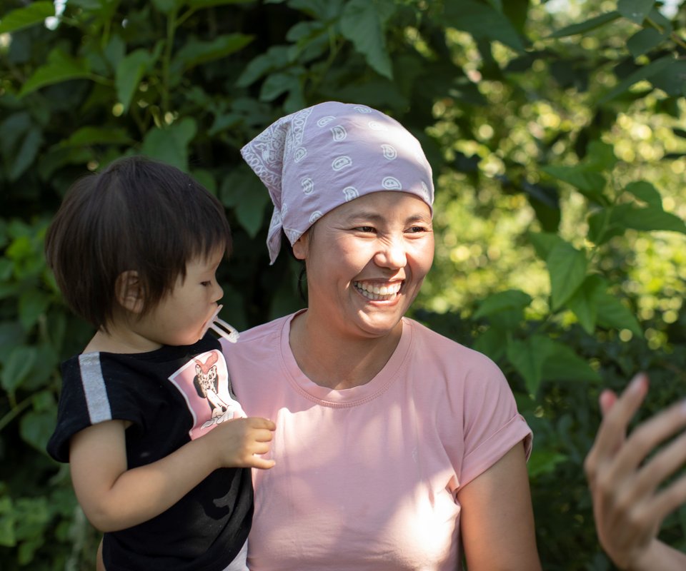 Smiling woman holding child.
